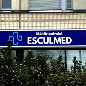 Laatikkovalomainos asennettuna seinälle